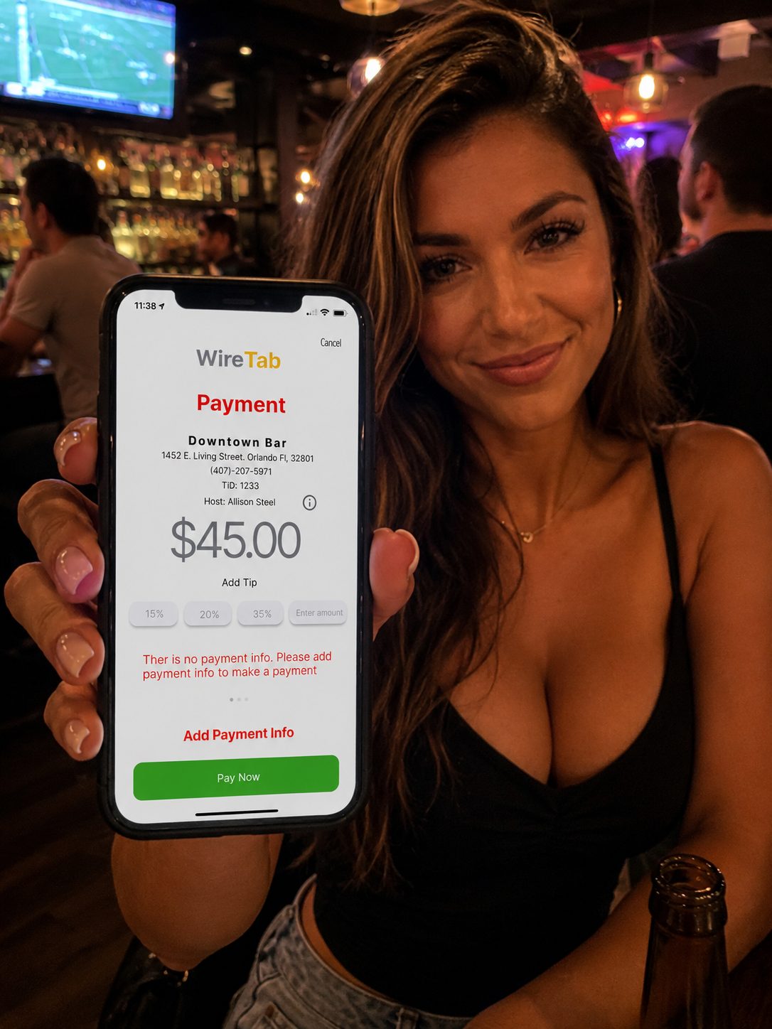 A woman at a bar holding up her phone showing the WireTab payment screen